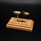 Front angled view of a handcrafted 9mm Luger cartridge anatomy display featuring a 115gr Sierra FMJ bullet with an engraved anatomy diagram showing the primer cup, anvil, cartridge case, powder, and projectile that is mounted on a solid cherry wood base.