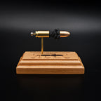 Front view of a handcrafted 9mm Luger cartridge anatomy display featuring a 115gr Sierra FMJ bullet with an engraved anatomy diagram showing the primer cup, anvil, cartridge case, powder, and projectile that is mounted on a solid cherry wood base.