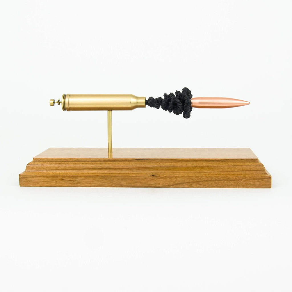 inert 338 win mag cartridge display on hardwood base