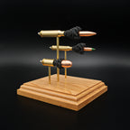 Front left angle of a triple caliber anatomy ammunition display showcasing a .308 Winchester Sierra MatchKing HPBT, 5.56×45mm M855 Green Tip, and .45 Auto Sierra FMJ with simulated powder on a handcrafted cherry wood base.