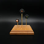 Bullet-forward view of a triple caliber exploded cartridge display highlighting the .308 Winchester 168gr Sierra MatchKing HPBT, 5.56×45mm M855 Green Tip, and .45 Auto 220gr Sierra FMJ on a handcrafted cherry wood base.