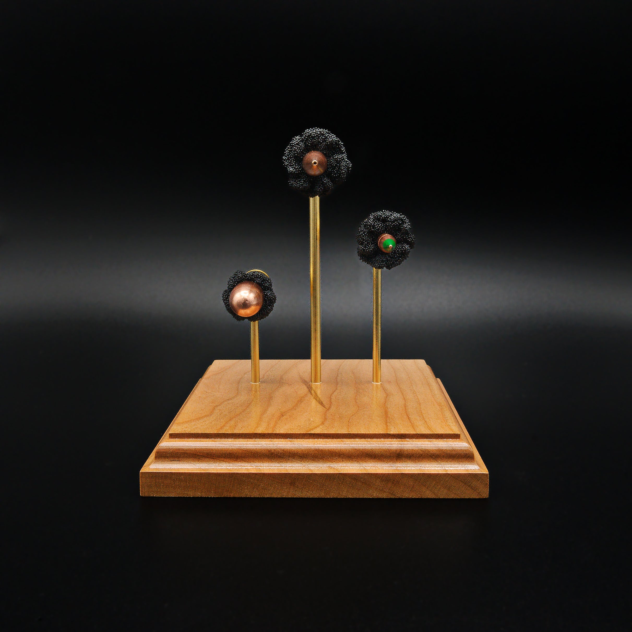 Bullet-forward view of a triple caliber exploded cartridge display highlighting the .308 Winchester 168gr Sierra MatchKing HPBT, 5.56×45mm M855 Green Tip, and .45 Auto 220gr Sierra FMJ on a handcrafted cherry wood base.