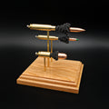 Angled front view of a triple caliber exploded ammunition display showcasing a .308 Winchester 168gr Sierra MatchKing HPBT, 5.56×45mm M855 Green Tip, and .45 Auto 220gr Sierra FMJ with simulated powder on a handcrafted cherry wood base.